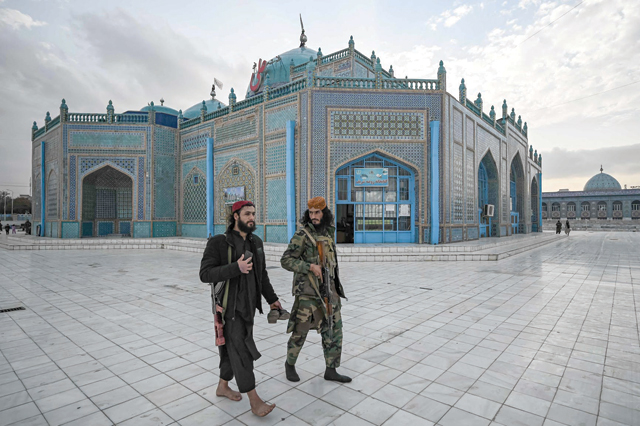Taliban fighters walk through the compound of the Hazrat-e-Ali shrine or Blue Mosque in Mazar-e-Sharif on Wednesday (AFP photo)