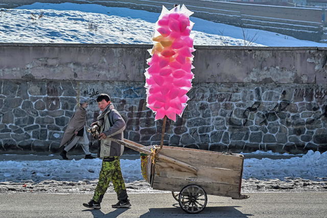 An Afghan boy pulls a cart containing cotton candy sweets along a street in Kabul, on Saturday (AFP photo)