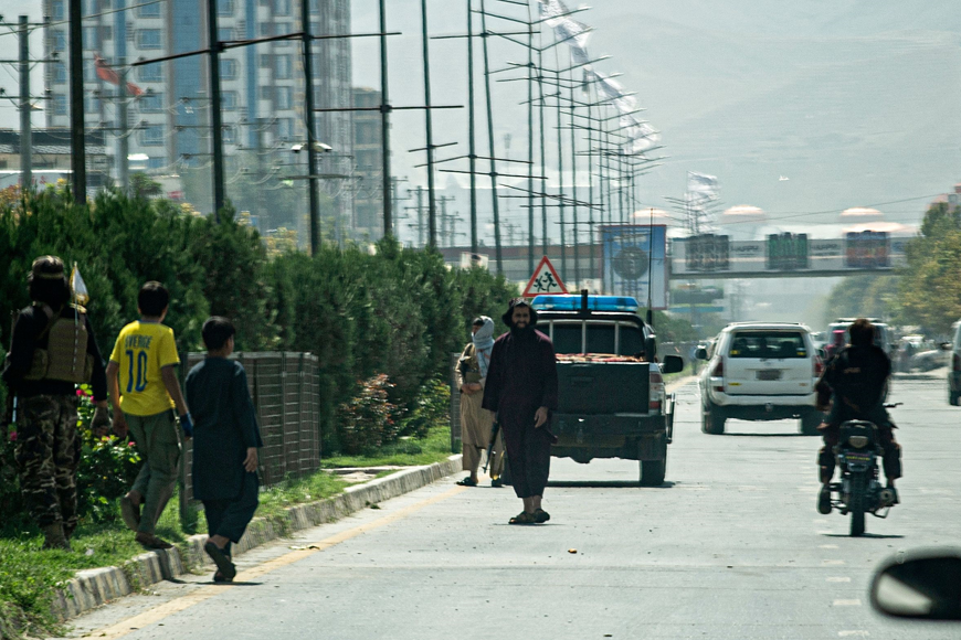 Taliban fighters (centre) stand guard along a road near the Russian embassy after a suicide attack in Kabul on Monday (AFP photo)