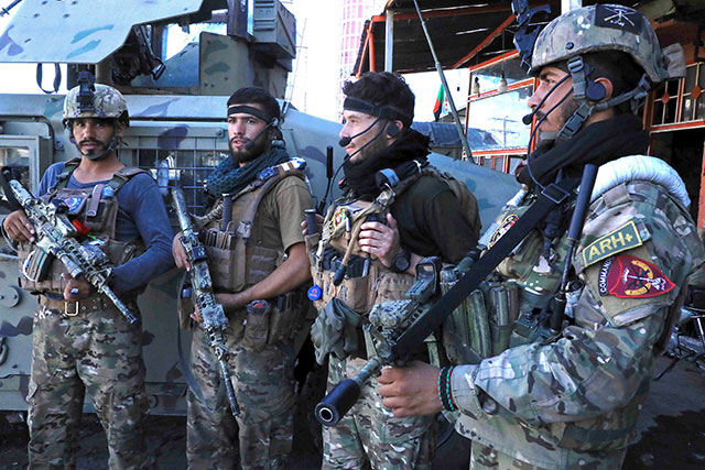 Afghan security force personnel stand guard along the roadside in Herat on Thursday, as Taliban took over the police headquarters in Herat, Afghanistan's third-largest city and also seized another key district capital just 150 kilometres  from capital Kabul (AFP photo)