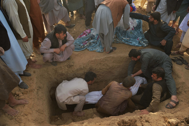 Relatives lower into a grave the body of a victim of Friday's suicide bomb attack on worshippers at a Shiite mosque, during the funeral at a graveyard in Kunduz on Saturday (AFP photo)