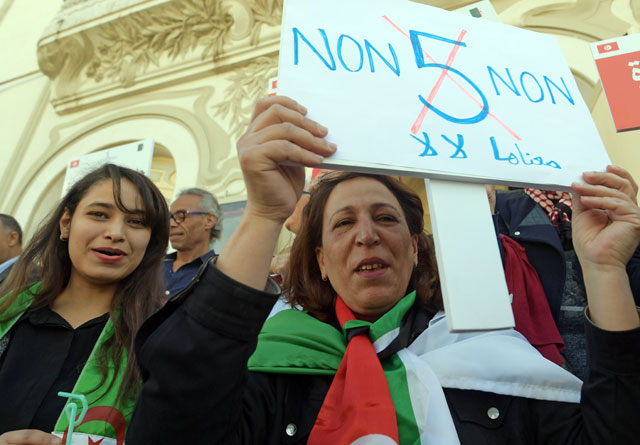 Tunisians and Algerians, living in Tunis, take part in a demonstration against Algerian ailing President Abdelaziz Bouteflika's bid for a fifth term in the capital Tunis on Saturday (AFP photo)