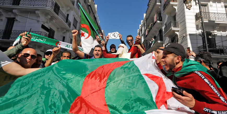 People carry their national flags as they protest over President Abdelaziz Bouteflika's decision to postpone elections and extend his fourth term in office in Algiers, Algeria, on Friday (Reuters photo)
