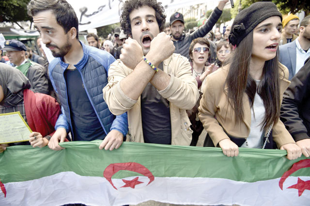 Algerian anti-government protesters chant slogans as they gather with national flags during a demonstration in the centre of the Algerian capital Algiers on Tuesday (AFP photo)
