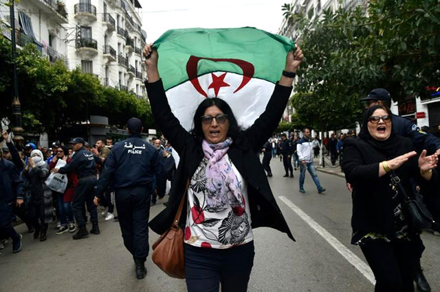 An Algerian woman waves a national flag as she takes part in an anti-government demonstration in the capital Algiers on March 14 (AFP photo)