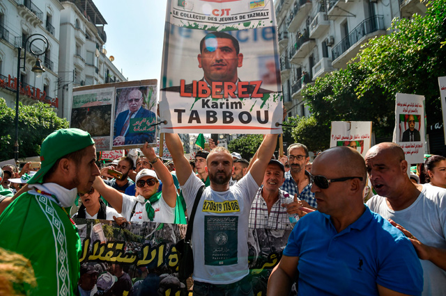  In this file photo taken on September 27, 2019, an Algerian protester marches with a sign calling to set free politician Karim Tabbou during a demonstration against the ruling class in the capital Algiers for the 32nd consecutive Friday since the movement  began (AFP photo)