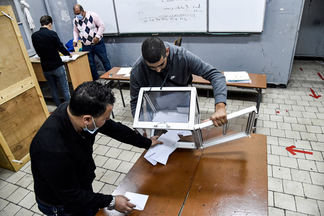 Poll station workers empty a ballot box to begin counting after a vote on a revised constitution ended at a station in Algeria's capital Algiers on Sunday (AFP photo)