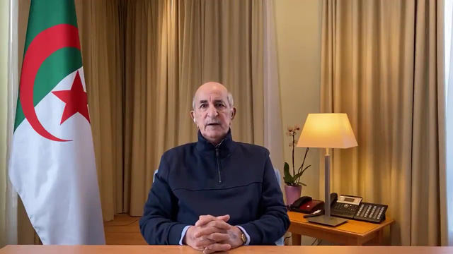 An image grab taken from a video published on the personal twitter account of Algeria’s President Abdelmadjid Tebboune on Sunday shows him delivering a speech to a camera next to an Algerian flag  (AFP photo)