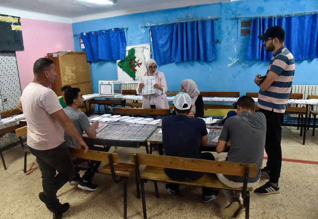 Algerian elections staff count ballots for parliamentary elections at a polling station in Bouchaoui, on the western outskirts of the capital Algiers, on Saturday  (AFP photo)