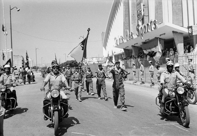 In this file photo taken on July 3, 1962, Algerian troops of the National Liberation Army parade in front of the Palais de Sports in Oran, during a ceremony celebrating Algeria's independence (AFP photo)