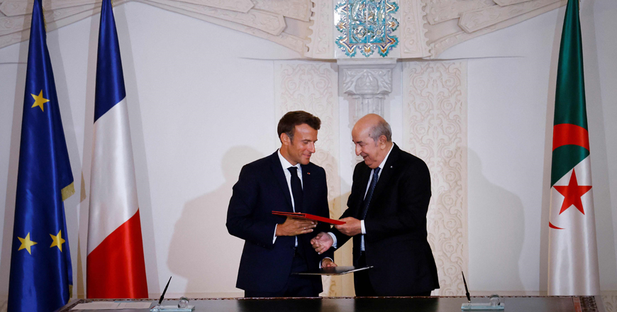 French President Emmanuel Macron and Algeria's President Abdelmadjid Tebboune  attend a signing ceremony in the pavilion of honour at Algiers airport, in Algiers, on Saturday (AFP photo)