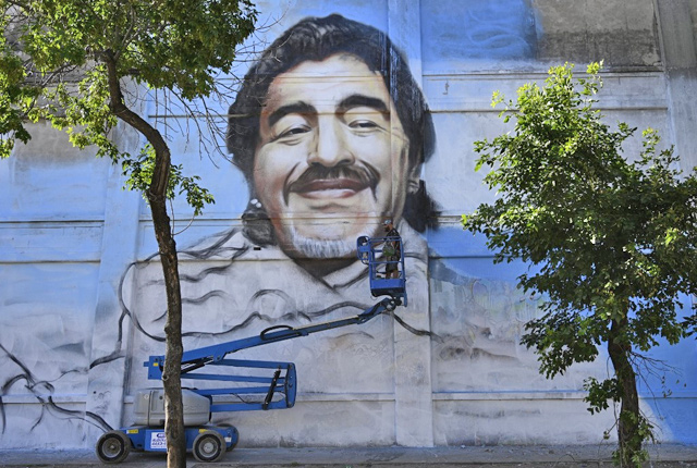 Argentine street artist Alfredo Segatori controls an elevator he uses to paint a mural of late Argentine football legend Diego Maradona in Buenos Aires on December 1 (AFP photo)