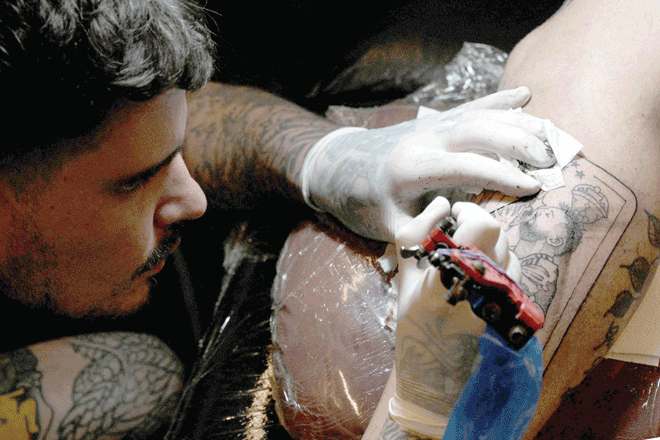 Argentinean tattooist Esteban Vucinovich has full hands of work these days with Argentinean fans swarming in to his tattoo parlour (AFP photo)