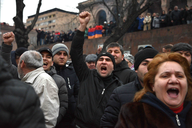Opposition supporters rally outside the national assembly building to demand Prime Minister Nikol Pashinyan’s resignation over his handling of last year’s war with Azerbaijan in Yerevan on Monday (AFP photo)