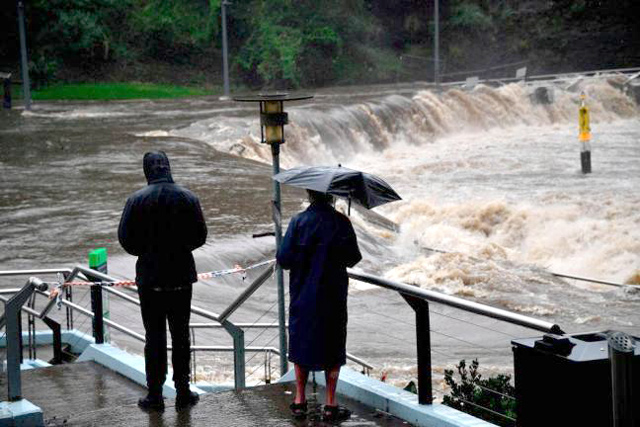 Residents from the neighbourhood watch the over flowing Parramatta river during heavy rain in Sydney, on Saturday (AFP photo)