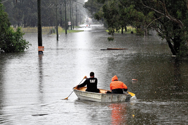 Residents commute on a boat in a flooded residential area near Windsor on Monday, as torrential downpours lashed Australia’s east forcing thousands to flee the worst flooding in decades (AFP photo)