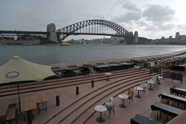 The Sydney Harbour Bridge is seen as the Sydney Opera House restaurant remains empty on Sunday, a day before the expected easing of coronavirus restrictions in Australia's largest city (AFP photo)