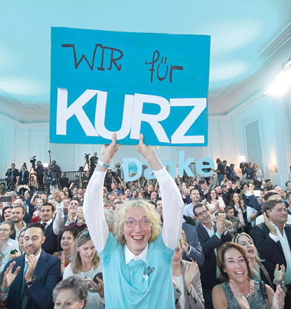 A supporter of Austria's People's Party holding a placard reading ‘We for Kurz’ reacts to exit polls during the party's electoral evening in Vienna, Austria, on Sunday  (AFP photo)