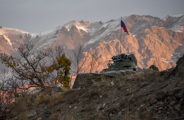 An armoured personnel carrier of Russian peacekeeping forces is stationed above the demarcation line near the village of Charektar on Wednesday, as Azerbaijan said its forces had entered the Kalbajar district, the second of three to be handed back by Armenia as part of a deal that ended weeks of fighting over Nagorno-Karabakh (AFP photo)