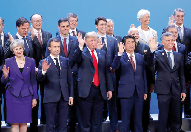 US President Donald Trump, Britain's Prime Minister Theresa May, French President Emmanuel Macron and Japanese Prime Minister Shinzo Abe wave hands during a family photo at the G-20 leaders summit in Buenos Aires, Argentina, on Friday (Reuters photo)