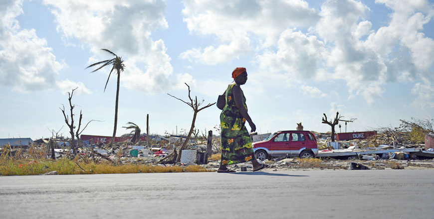 A woman walks by damage in Marsh Harbour, Bahamas, on Saturday, in the aftermath of Hurricane Dorian (AFP photo)
