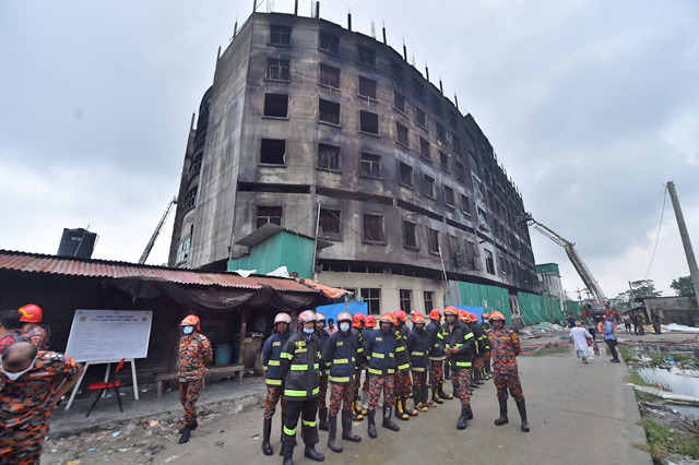 Firemen line up after putting out a fire at the burnt factory in Rupganj on Saturday (AFP photo)