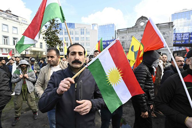 A protester holds a Kurdish flag during a rally gathering the Kurdish community, following the Mar. 24 riots in Heusden-Zolder, in Brussels on Monday (AFP photo)