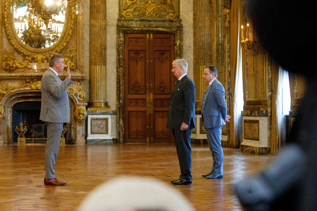 Vice-prime minister and Minister of Finance, Combating Tax Fraud, Pensions, National Lottery and Cultural Institutions Jan Jambon raises his hand in front of Belgium's Prime Minister Bart De Wever and King Philippe - Filip of Belgium during the oath taking ceremony of the new Prime Minister and members of the federal government at The Royal Palace in Brussels on Monday - Belgium OUT (AFP photo)