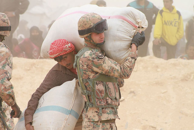 Border Guards help Syrians cross the border into Jordan in this May 4 photo (Photo by Hassan Tamimi)