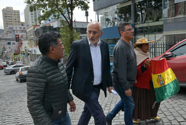 The opposition runner-up in Bolivia’s recent polls, Carlos Mesa (second left), leaves Avaroa de La Paz Square in La Paz after speaking to the press on Sunday (AFP photo)