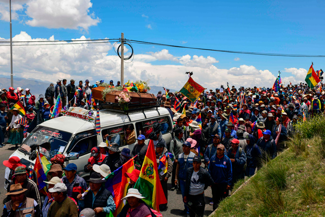 People attend a funeral procession of eight supporters of Bolivia's ex-president Evo Morales, killed when security forces lifted a siege on a fuel plant, from El Alto to La Paz, on Thursday (AFP photo)