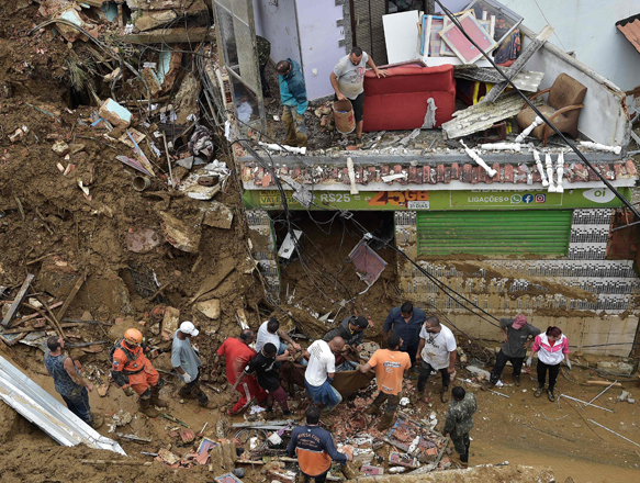 People carry the corpse of a victim out of the rubble after a mudslide in Petropolis, Brazil, on Wednesday  (AFP photo)