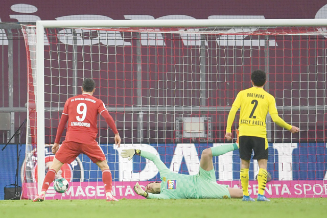 Bayern Munich's Polish forward Robert Lewandowski (left) scores his team's fourth goal during the German first division Bundesliga football match between FC Bayern Munich and BVB Borussia Dortmund in Munich, southern Germany, on Saturday (AFP photo)