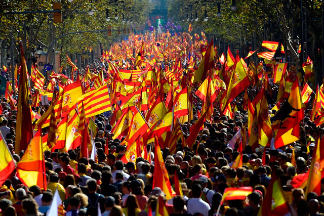 Protesters wave Spanish and Catalan Senyera flags during a pro-unity demonstration in Barcelona on Sunday (AFP photo)