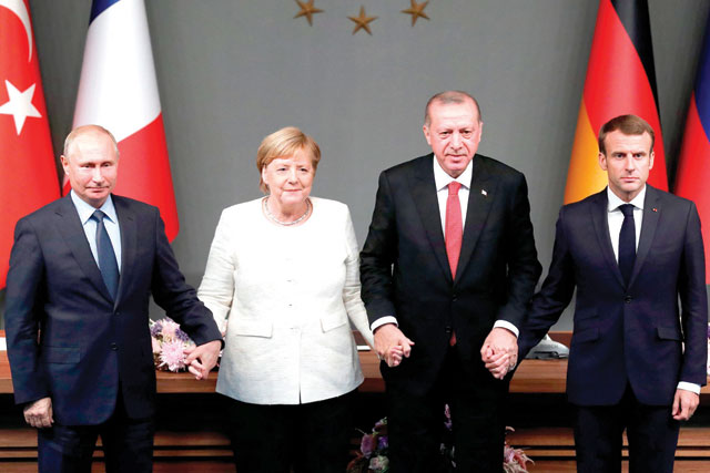 Russian President Vladimir Putin, German Chancellor Angela Merkel, Turkish President Recep Tayyip Erdogan and French President Emmanuel Macron hold hands after a conference as part of a summit called to attempt to find a lasting political solution to the civil war in Syria, which has claimed in excess of 350 000 lives, at Vahdettin Mansion in Istanbul on Saturday (AFP photo)