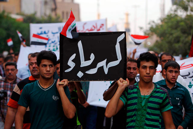 Iraqi protesters hold a mock-coffin during a demonstration against corruption and poor services, in the Shiite shrine city of Karbala, south of Baghdad, on August 6, 2015. The writing in Arabic reads: ‘Electricity’ (AFP photo)
