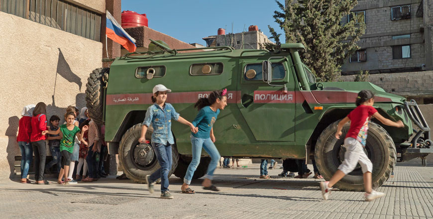 Syrian kids run past a Russian military truck during a guided tour with the Russian army on Monday  (AFP photo)