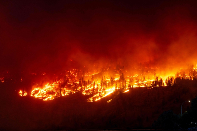 File photo of the McDougall Creek wildfire burns in the hills in West Kelowna, British Columbia, Canada, on August 17 (AFP photo)