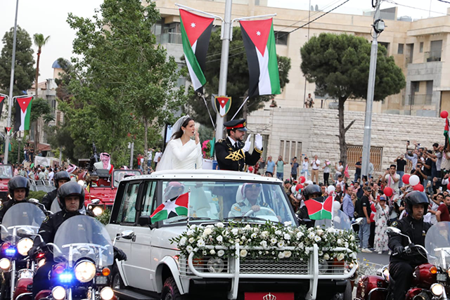Their Royal Highnesses Crown Prince Hussein and Princess Rajwa Al Hussein greet the public during the Royal Red Motorcade procession following their wedding ceremony on Thursday (Petra photos)