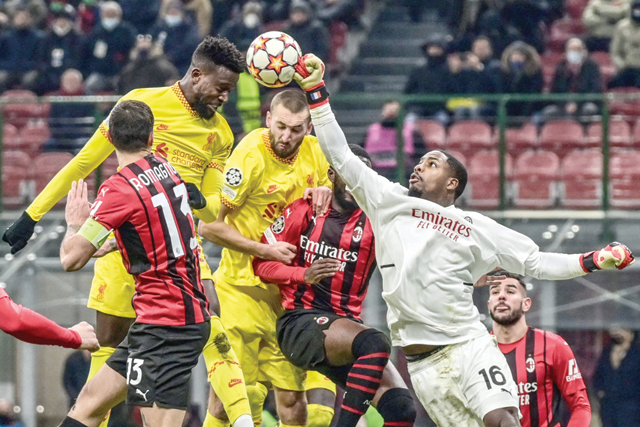 Liverpool's Belgian forward Divock Origi (top left) and AC Milan's French goalkeeper Mike Maignan (right) go for the ball during the UEFA Champions League Group B football match between AC Milan and Liverpool on Tuesday at the San Siro Stadium in Milan (AFP photo)