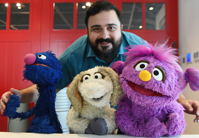 Hadi, the name of the character portrayed by actor Rami Delshad, poses for a photo with Grover (Gargur in Arabic) (left), Mazooza (centre) and Basma  from the Sesame Street television series, in Dubai, on January 28  (AFP photo)