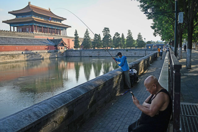 An angler fishes outside the Forbidden City in Beijing, on Wednesday  (AFP photo)