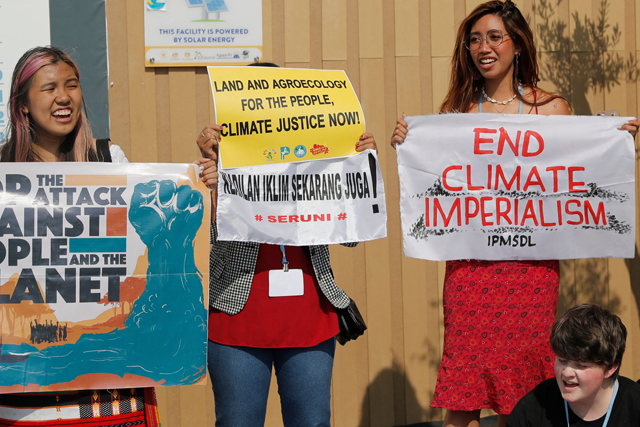 Youth activist Mitzi Jonelle Tan (right) of the Philippines holds a banner during a climate demonstration at the Sharm El Sheikh International Convention Centre, during the COP27 climate conference in Egypt's Red Sea resort city of the same name, on Monday (AFP photo)