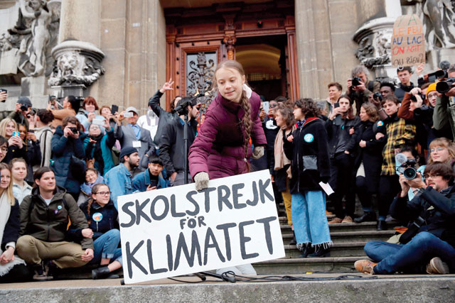 17-year-old Swedish climate activist Greta Thunberg (centre) holds a placard reading 'School strike for Climate' during a climate strike against governmental inaction towards climate breakdown and environmental pollution in Lausanne on Friday (AFP photo)