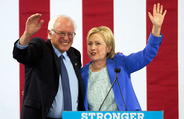 Democratic presidential candidate Hillary Clinton waves to supporters with Sen. Bernie Sanders, during a rally in Portsmouth, Tuesday, where Sanders endorsed her for president (AP photo)