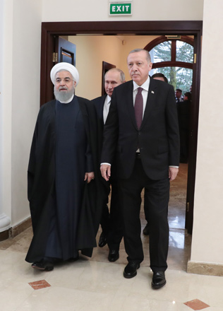 A handout photo taken and released on Thursday by the Turkish Presidential Press service shows Iranian President Hassan Rouhani (left), Russian President Vladimir Putin (centre) and Turkish President Recep Tayyip Erdogan walking together during a trilateral meeting on Syria in the Black Sea resort of Sochi (AFP photo)