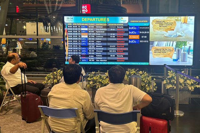 Passengers look at a flight information display board in a waiting area at Kempegowda International Airport following a global IT outage, in Bengaluru, India (AFP photo)