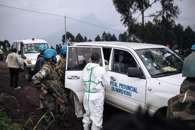 A medical vehicle of the North Kivu hospital is loaded with the body of the driver on a road on the edge of the Virunga National Park near the village of Kibumba, some 25km from Goma, on Monday (AFP photo)