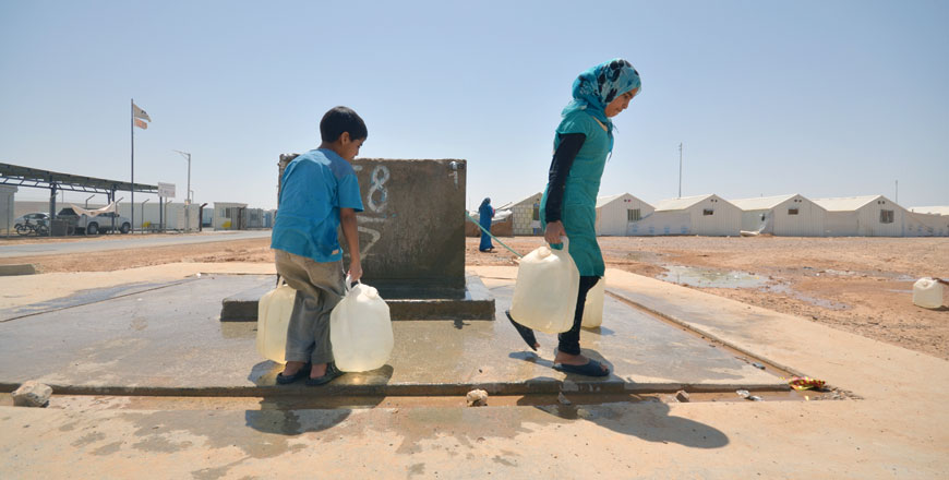 Syrian refugees carry water at the Azraq camp, some 100km east of Amman and 20km west of the town of Azraq in Zarqa Governorate, recently (Photo by Muath Freij)