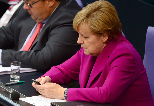 This file photo taken on June 4, 2014 shows German Chancellor Angela Merkel holding her mobile phone during a session of the Bundestag Lower House of parliament in Berlin. The US spied on top politicians in Europe, including German Chancellor Angela Merkel, from 2012 to 2014 with the help of Danish intelligence, Danish and European media reported on Sunday (AFP photo)